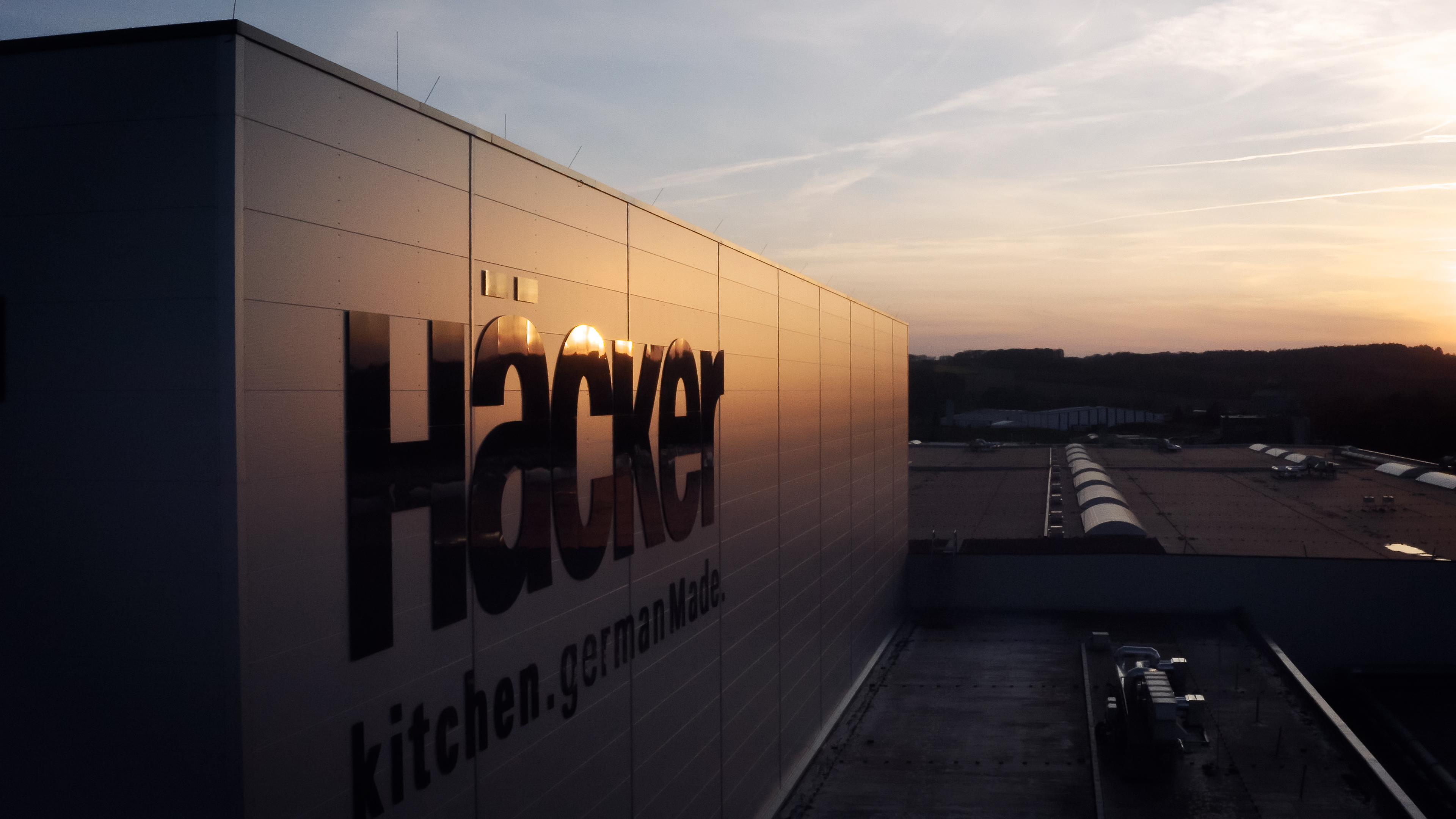 Häcker Firmengebäude mit Namens-Schriftzug im Abendlicht